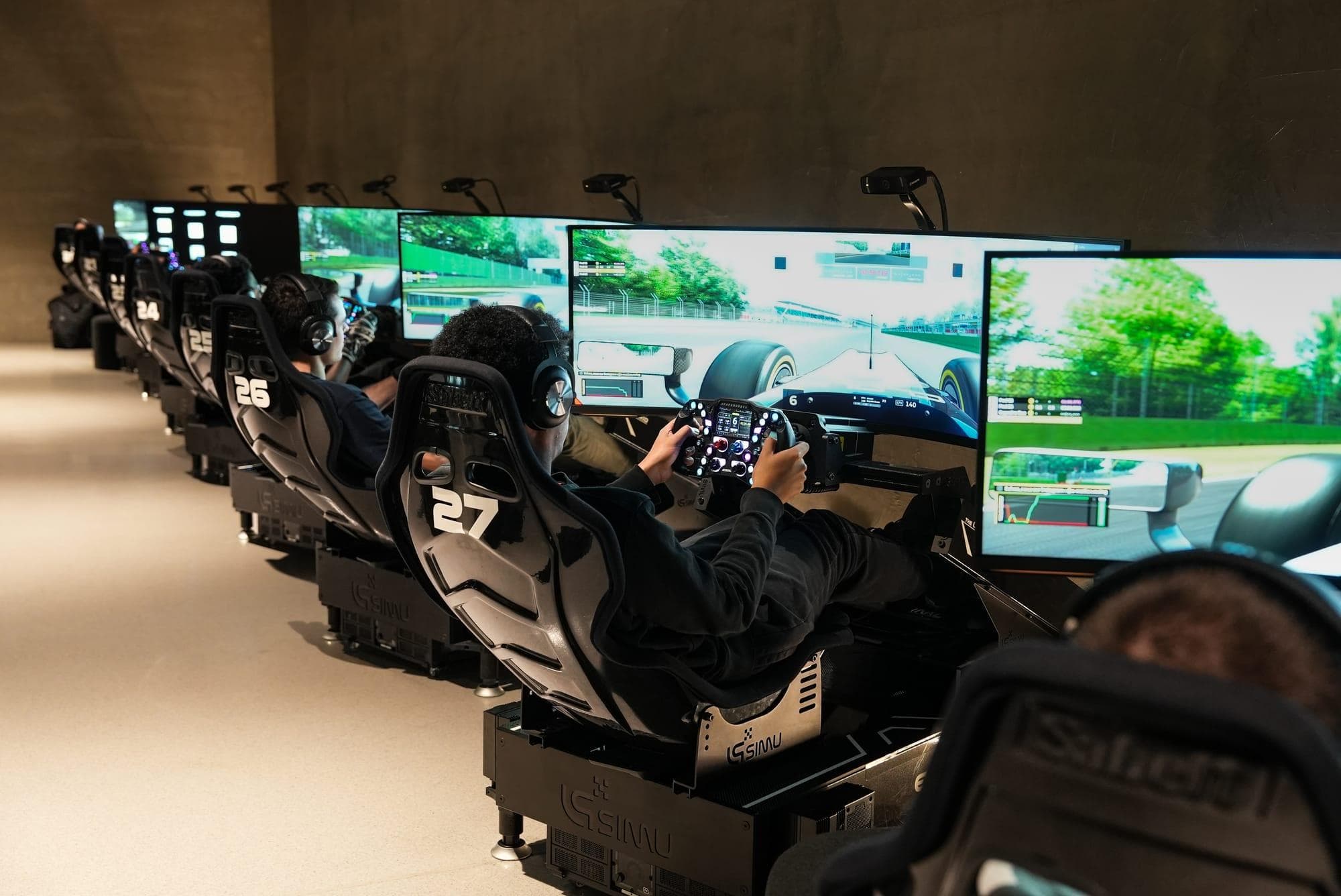 Row of direct-drive sim racing rigs set up for endurance racing